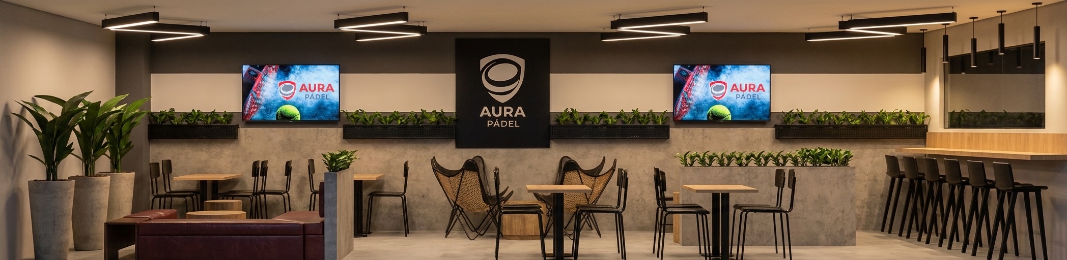 Vista panorámica del salón de Aura Pádel con pantallas, barra y mesas