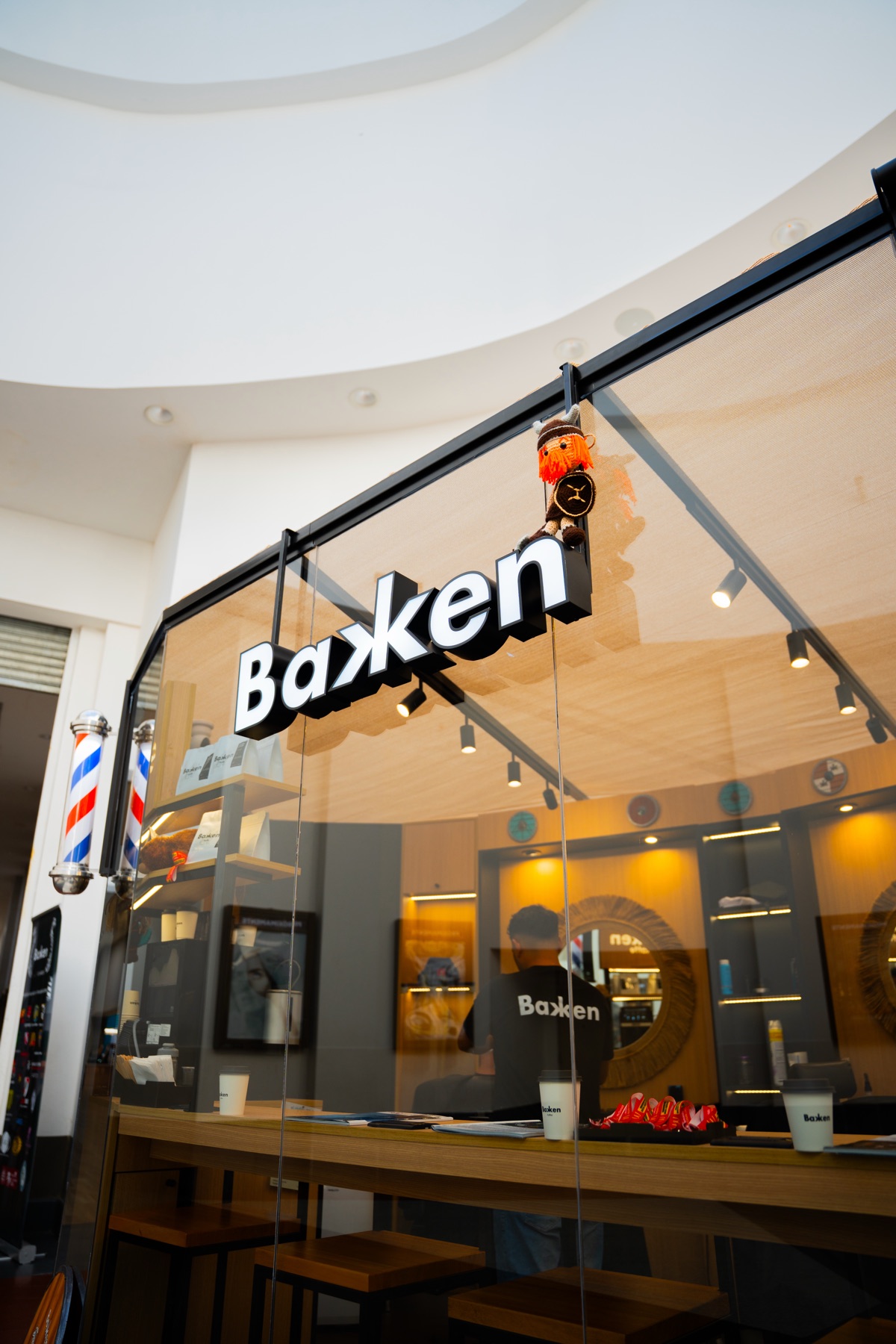Frente vidriado de Bakken Barbería con cartel corpóreo y poste de barbero