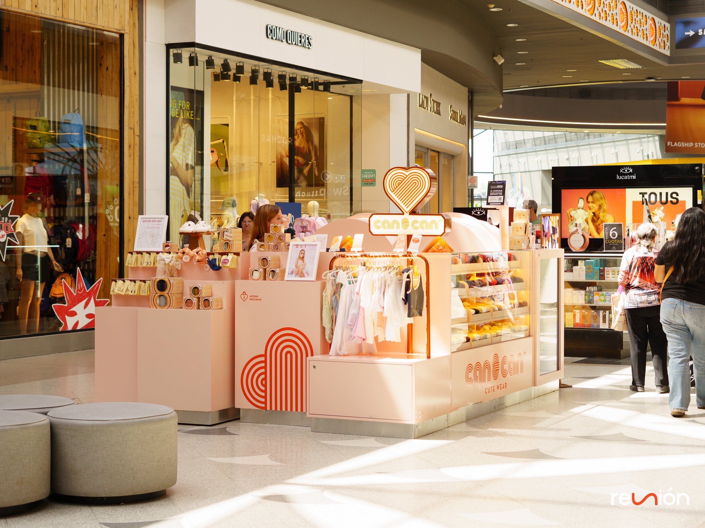 Stand de Can & Can en tonos durazno con exhibidores de ropa y accesorios